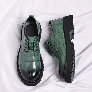 Detail van groene herenlederen schoenen met krokodillenpatroon en dikke zwarte zool