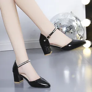 Elegant black pointed-toe block heel sandals with pearl-embellished ankle straps on a model.