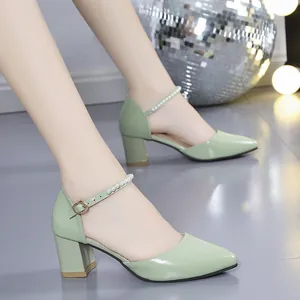 Close-up of elegant green block heel sandals featuring a pearl-embellished ankle strap