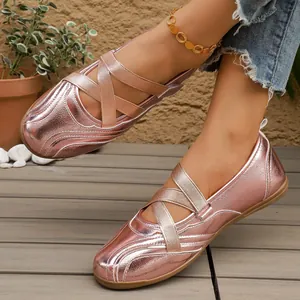 Close-up view of metallic rose gold Mary Jane flats featuring elastic cross straps on a model