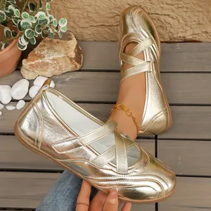 Close-up of metallic gold Mary Jane ballet flats with stylish cross straps on wood deck
