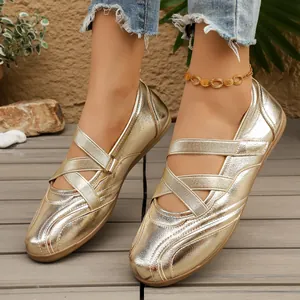 Detailed view of metallic gold Mary Jane flats with criss-cross straps