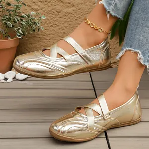 Detailed view of stylish metallic gold Mary Jane flats featuring elastic cross straps