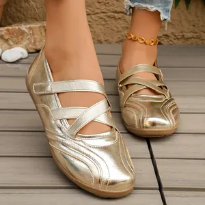 Close-up of shiny gold metallic Mary Jane shoes with crisscross elastic straps