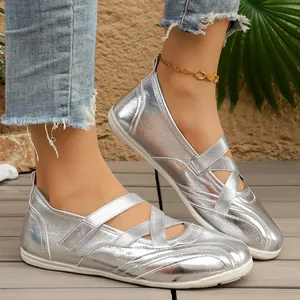 Detailed shot of metallic silver Mary Jane flats featuring stylish cross straps on feet