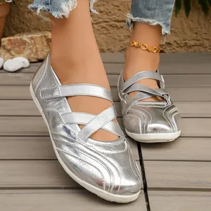 Detailed view of silver metallic Mary Jane flats with criss-cross straps and white soft sole.