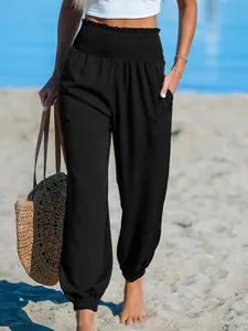 Close-up detail of black high-waisted beach joggers with smocked waistband and side pockets