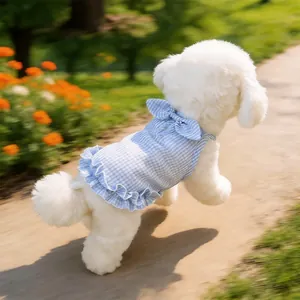 Detailed view of blue gingham dog dress featuring ruffled hem and a decorative bow