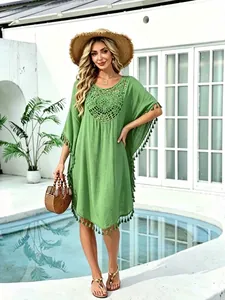 Green beach cover-up with crochet lace and tassel trim over bikini