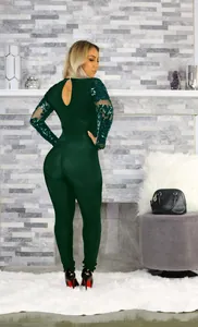 Dettaglio posteriore di una tutina verde scuro con maniche in rete e paillettes.