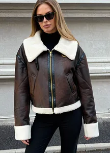 Detailansicht einer braunen Kunstwildlederjacke mit weißem Lammfellkragen und -bündchen