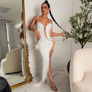 Full view of elegant white spaghetti strap evening gown with rhinestone details and high slit