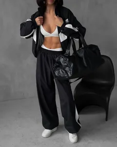 Stylish women's black and white colorblock tracksuit with zipper jacket and wide-leg pants