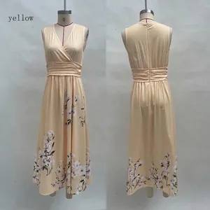 Détail d'une robe longue jaune sans manches à col en V avec imprimé fleuri sur l'ourlet