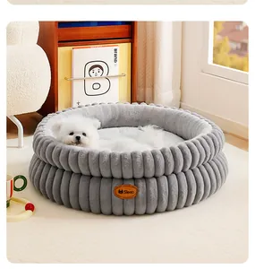 Gros plan d'un panier rond en peluche grise avec un petit chiot blanc à l'intérieur