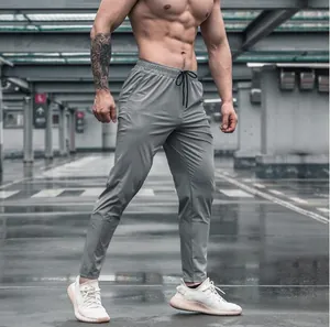 Athletic men's quick-dry fitness joggers in grey showing slim fit and elastic waist.