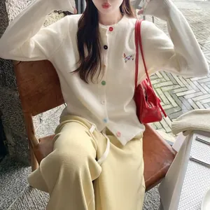 Close-up of women's white knit cardigan with cute puppy embroidery and colorful buttons