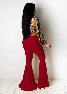 Rear view of red high-waisted flare pants with pleated lotus leaf hem and printed top