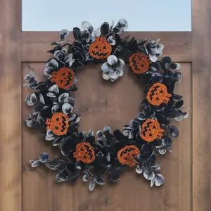 Decorative Halloween eucalyptus wreath featuring orange glitter Jack-o-lantern pumpkins