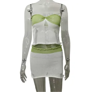 Vista detallada de un conjunto de top bandeau y minifalda de punto desgastado verde