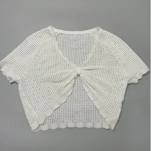 Dettaglio del cardigan corto bianco in maglia traforata con eleganti bordi a smerlo