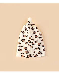 Close-up of a plush pet Christmas hat featuring a classic leopard print and soft white pom-pom.