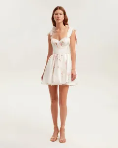Detailed full length shot of white organza dress with floral print and shoulder ties