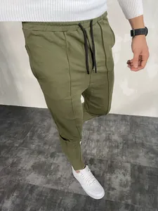 Primo piano dei pantaloni sportivi uomo slim fit verde oliva con coulisse e cucitura.