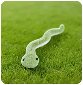 Gros plan d'une peluche de serpent vert mignon avec texture douce sur de l'herbe