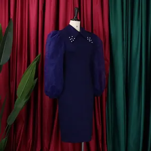 Detail of navy blue pencil dress with mesh puff sleeves and pearl embellished collar.