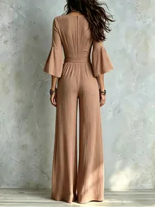Back view of a camel wide-leg jumpsuit with bell sleeves and high-waist belt.