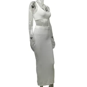 Side view of white knitted two-piece set featuring crop top and bodycon maxi skirt.