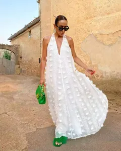 Robe longue blanche élégante avec licou, col en V et fleurs 3D pour les vacances d'été.