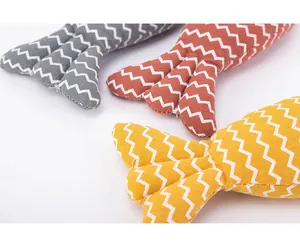 Gros plan de jouets pour chats en forme de poisson avec motif zigzag et tissu.