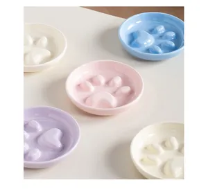 Ceramic paw print slow feeder pet bowls in multiple pastel colors for dogs and cats