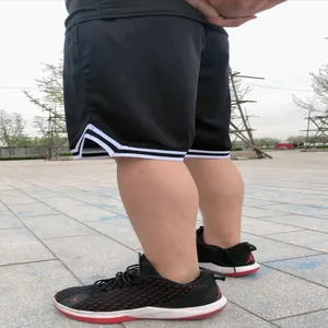 Vista laterale dettagliata dei pantaloncini da basket neri in mesh con strisce bianche