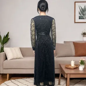 Back view of elegant black sequin mesh evening maxi dress in a living room setting
