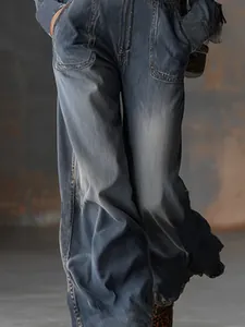 Détail d'une combinaison en jean délavé bleu-gris rétro avec jambes larges