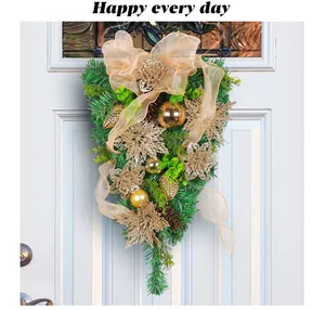 Detailed view of a golden Christmas teardrop wreath with pine needles and baubles