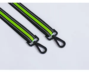 Close-up of durable metal clips and reflective neon green dog leash straps for night safety
