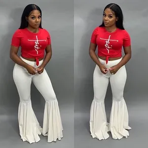 Detalle de los pantalones de campana con volantes blancos para mujer con top rojo sexy.