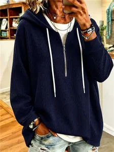 Detailed view of women's navy blue waffle knit hoodie with drawstring and zipper