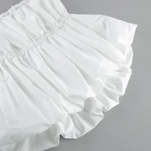 Close-up detail of white gathered strapless tube top with elegant ruffled fabric texture