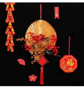 Close-up of a festive Chinese New Year hanging decoration with red berries and golden fan.