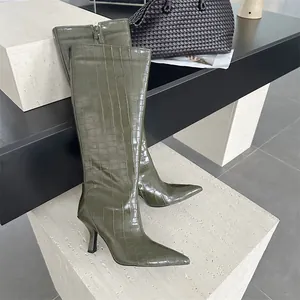Detailansicht der olivgrünen Kniehohen Stiefel mit Krokodilprägung und spitzer Zehenpartie