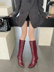 Detail view of burgundy pointed-toe knight boots with stiletto heel and leather finish