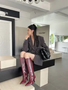 Stylish dark red knee-high knight boots featuring a pointed toe and slim high heels.