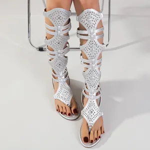 Silberne, hochgeschnittene Gladiator-Sandalen mit Nieten und flacher Sohle für Damen.