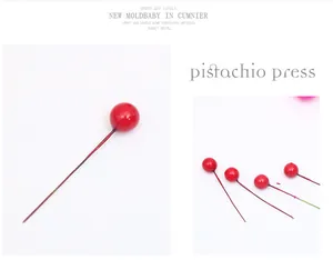 Close-up of small artificial red berries on wires for Christmas DIY decorations