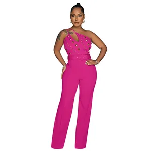 Full view of hot pink one-shoulder jumpsuit with gold stud detailing and belt